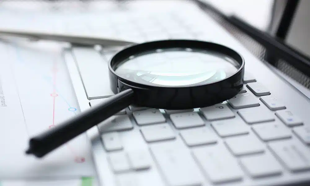 Lente di ingrandimento su computer per ricerca informatica